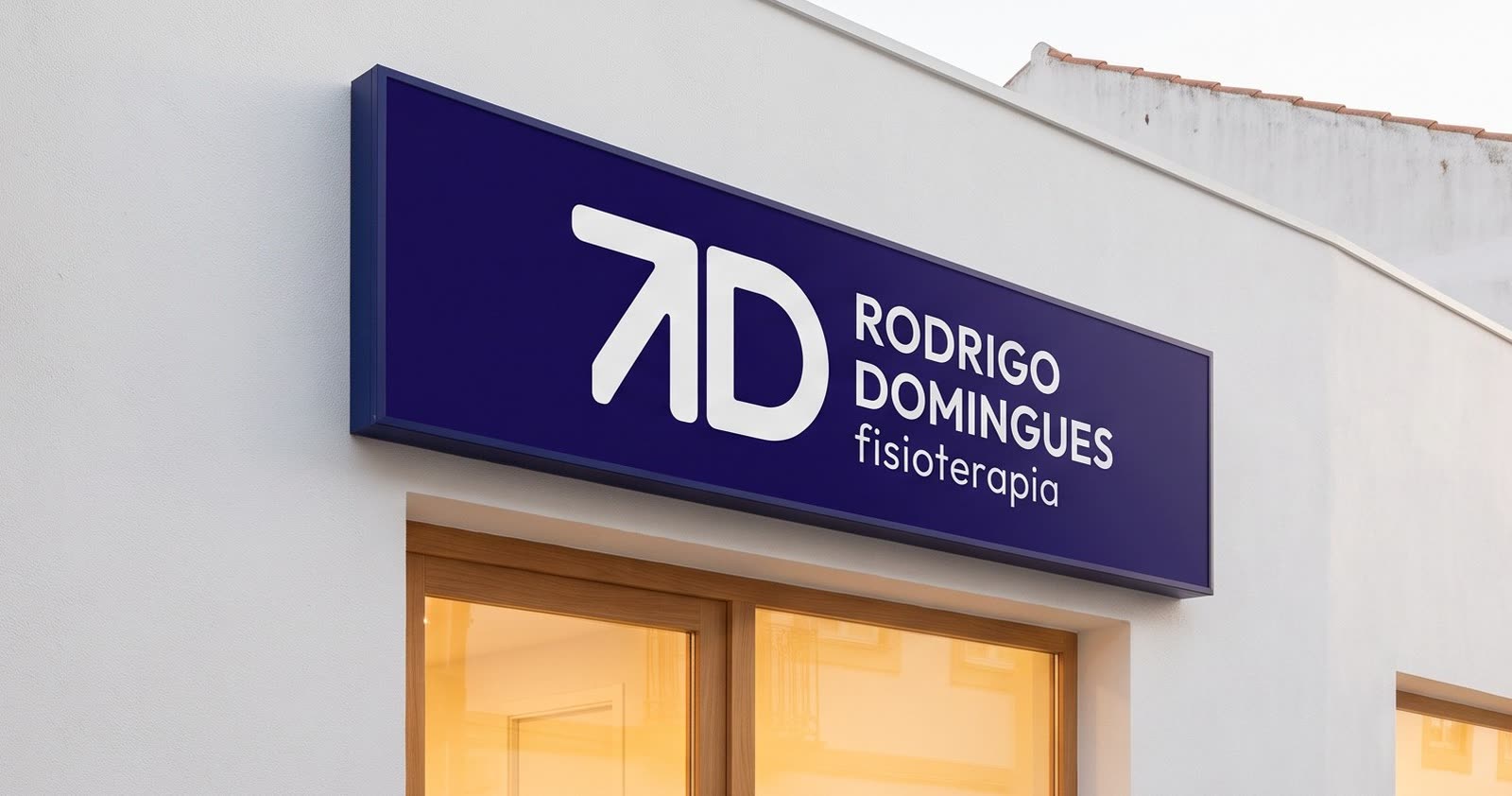 Fachada da clínica ao fim do dia, com o logótipo iluminado